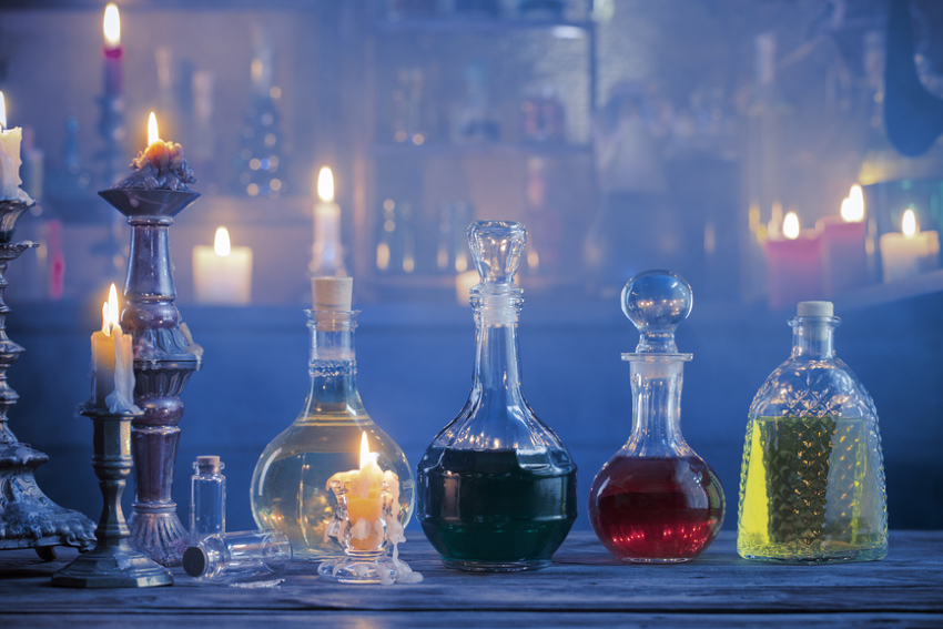 Magic potions in bottles on wooden background