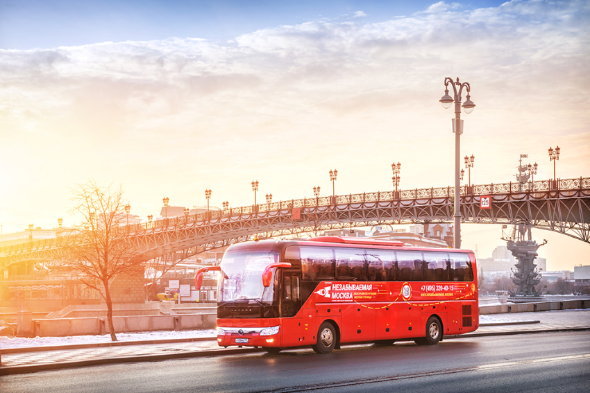 Красный туристический автобус Yutong на рассвете у Патриаршего моста